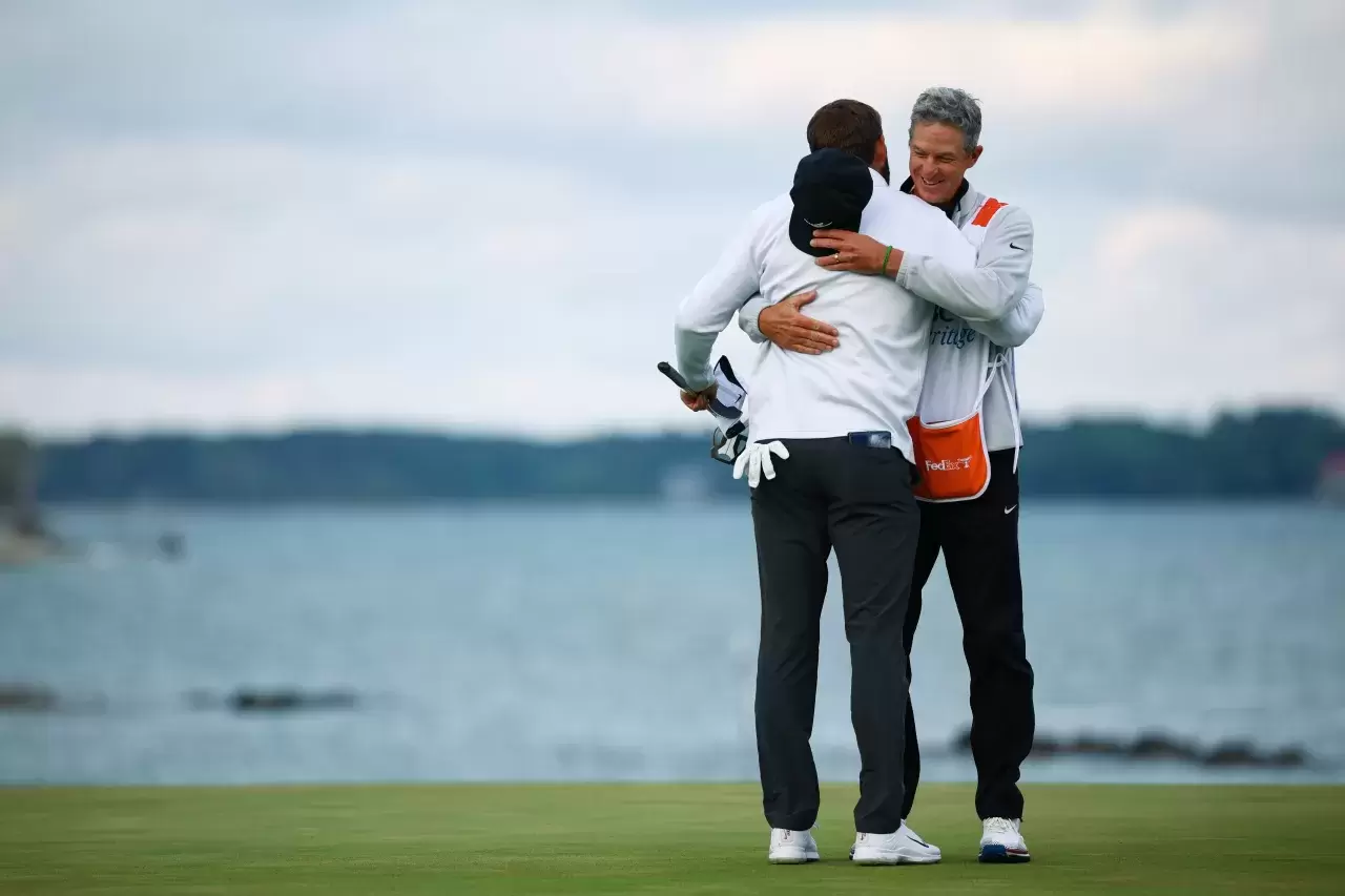 Scottie Scheffler of the United States celebrates with his caddie Ted Scott after winning on the 18th green during the continuation of the final round of the RBC Heritage at Harbour Town Golf Links